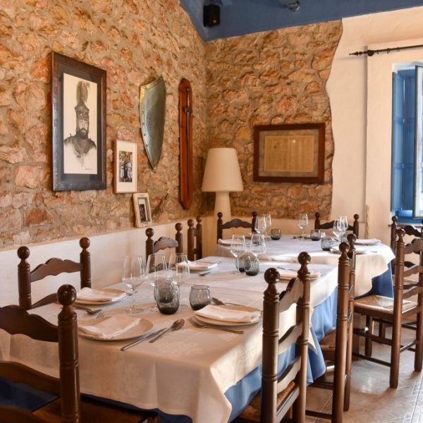 Comedor rústico con paredes de piedra y mesas de La Giralda en Dénia